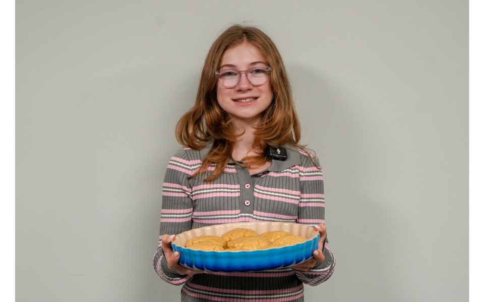 A girl holds a plate of cookies